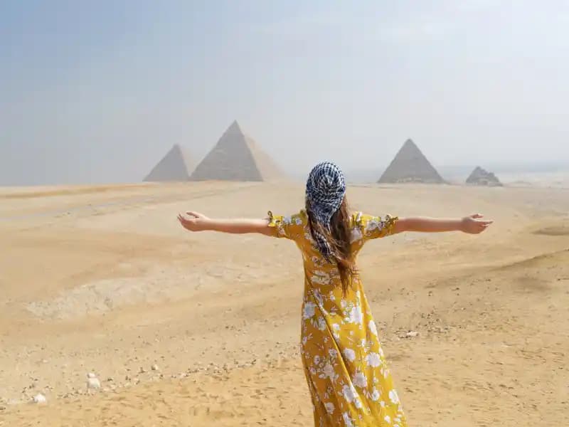 A tourist enjoying the view of the Giza Pyramids A tourist enjoying the view of the Giza Pyramids