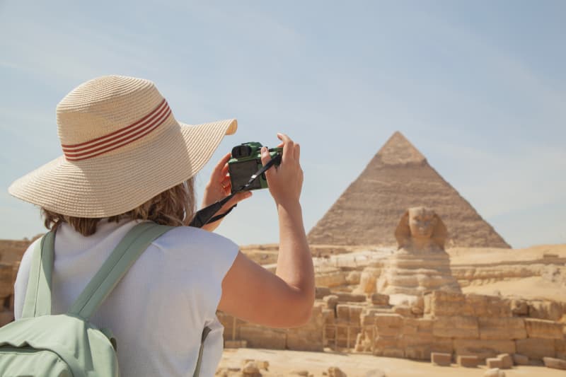 Pyramiden von Gizeh – unvergessliches Erlebnis in Kairo Touristin fotografiert die Pyramiden von Gizeh und die Sphinx