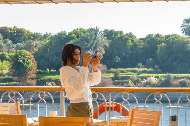 A woman taking photo to the Nile river A woman taking photo to the Nile river