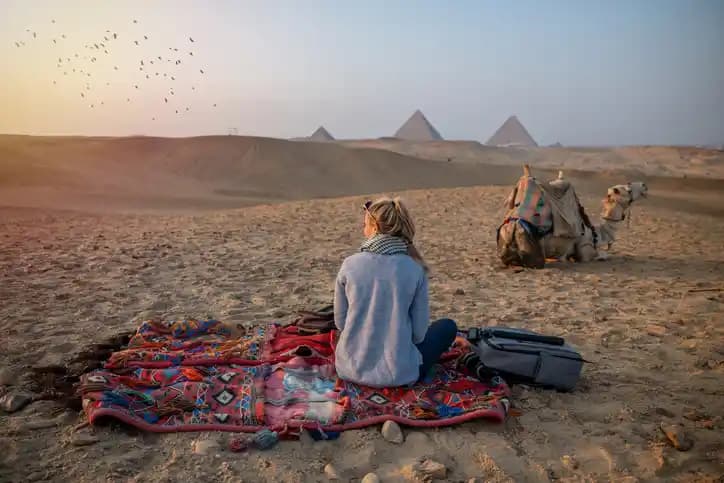 A female woman sitting in front of Giza Pyramids A female woman sitting in front of Giza Pyramids
