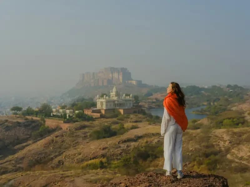 Forte Mehrangarh em Jodhpur mulher-com-xale-laranja-contemplando-vista-panoramica-do-forte-mehrangarh-e-do-jaswant-thada-em-jodhpur-india