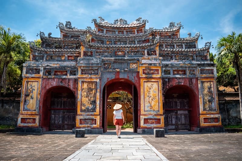 Cidadela Imperial de Hue, Vietnã mulher-com-chapeu-conico-atravessando-portao-ornamentado-da-cidadela-imperial-de-hue-no-vietna