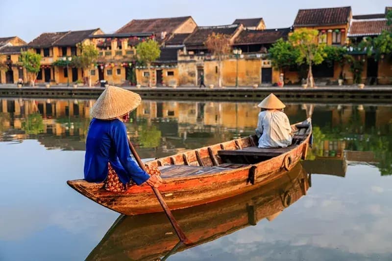 Rio Thu Bon, Hoi An, Vietnã barqueiros-com-chapeus-conicos-remando-em-barco-de-madeira-no-rio-diante-das-casas-antigas-de-hoi-an-vietna