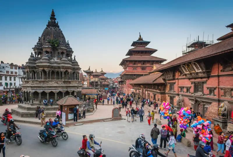Praça Durbar de Patan ao entardecer vista-panoramica-da-movimentada-praca-durbar-de-patan-com-templos-historicos-pessoas-e-vendedores-de-baloes-no-nepal