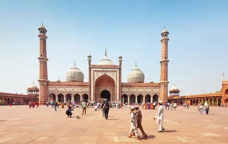 Jama Masjid em Delhi pessoas-caminhando-pelo-patio-da-jama-masjid-com-seus-minaretes-e-cupulas-de-marmore-delhi-india