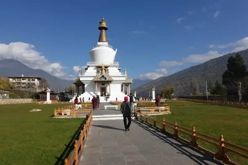 Memorial Chorten, Thimphu pessoas-caminhando-em-direcao-ao-memorial-chorten-branco-e-dourado-cercado-por-montanhas-em-thimphu-butao