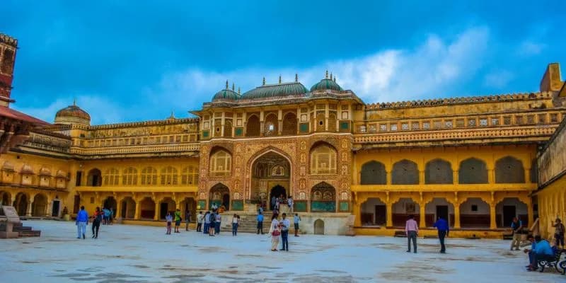 Amber Fort tourists-walking-through-the-courtyard-of-amber-fort-with-its-ornate-golden-facade-and-green-domes-jaipur-india