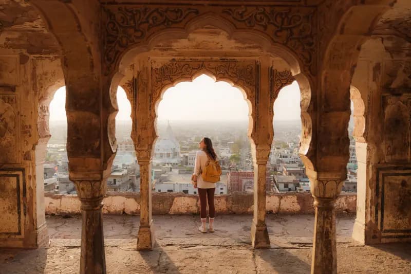 Mehrangarh Fort in Jodhpur woman-with-a-yellow-backpack-standing-beneath-ornate-arched-pavilions-at-mehrangarh-fort-overlooking-jodhpur-india