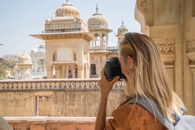Jaipur, Rajasthan woman-photographing-the-ornately-domed-marble-cenotaphs-at-royal-gaitor-in-jaipur-rajasthan