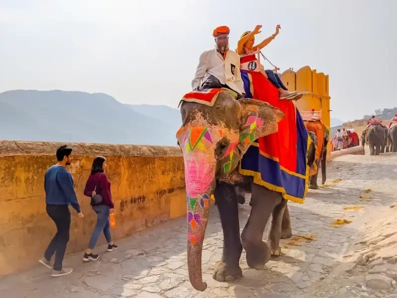 Amber Fort in Jaipur decorated-elephant-carrying-tourists-at-amber-fort-with-colorful-painted-patterns-and-mountains-in-the-background-jaipur-india