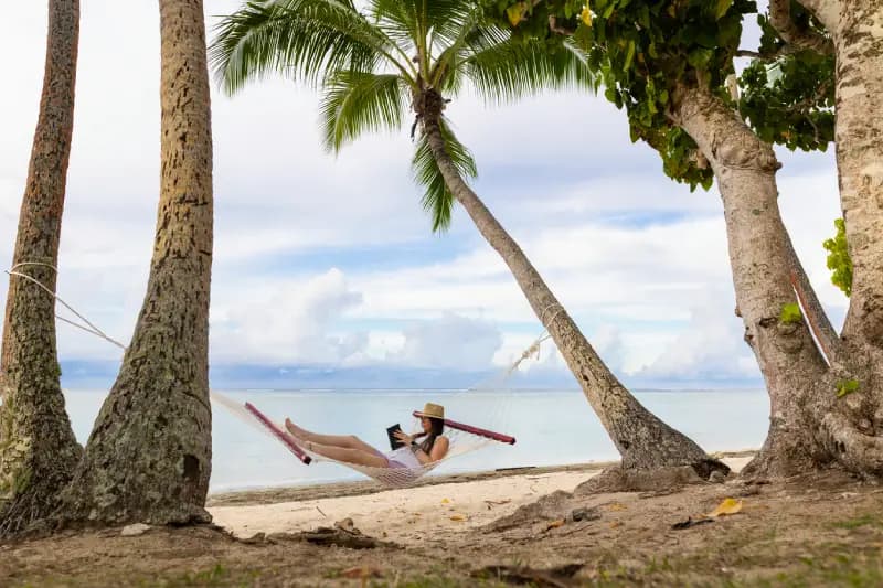Beach in fiji woman-relaxing-in-a-hammock-between-palm-trees-on-a-tropical-beach-in-fiji-reading-a-book