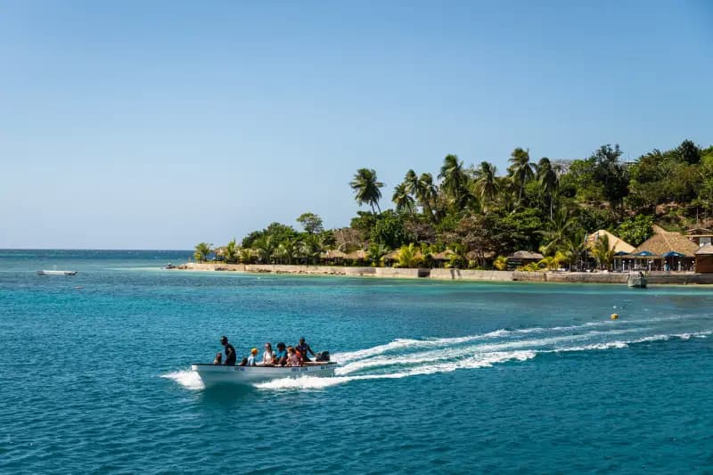 Fiji island small-boat-with-passengers-speeding-across-turquoise-water-near-a-tropical-island-in-fiji