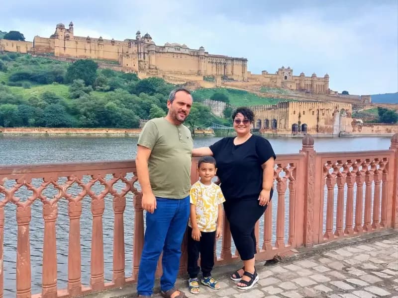 Amber Fort in Jaipur family-posing-by-a-lakeside-railing-with-amber-fort-visible-on-the-hillside-in-the-background-jaipur-india