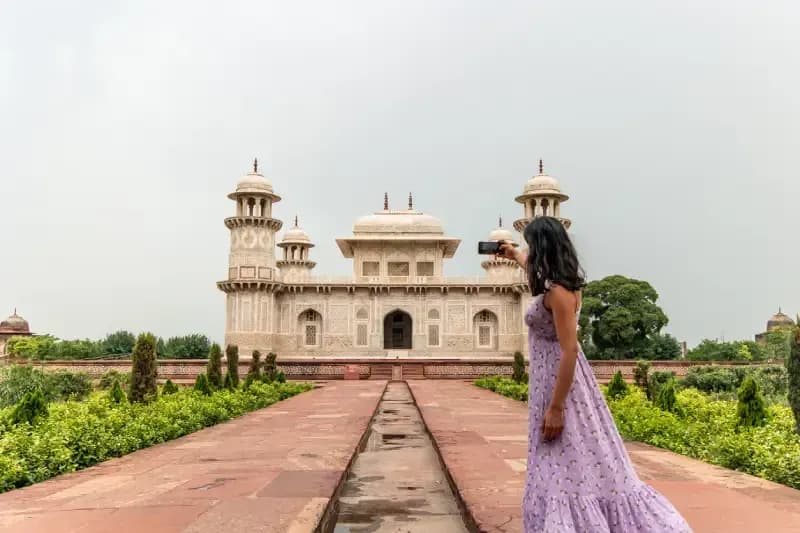 Agra in India woman-photographing-the-marble-mausoleum-of-itmad-ud-daulah-the-baby-taj-in-agra-india